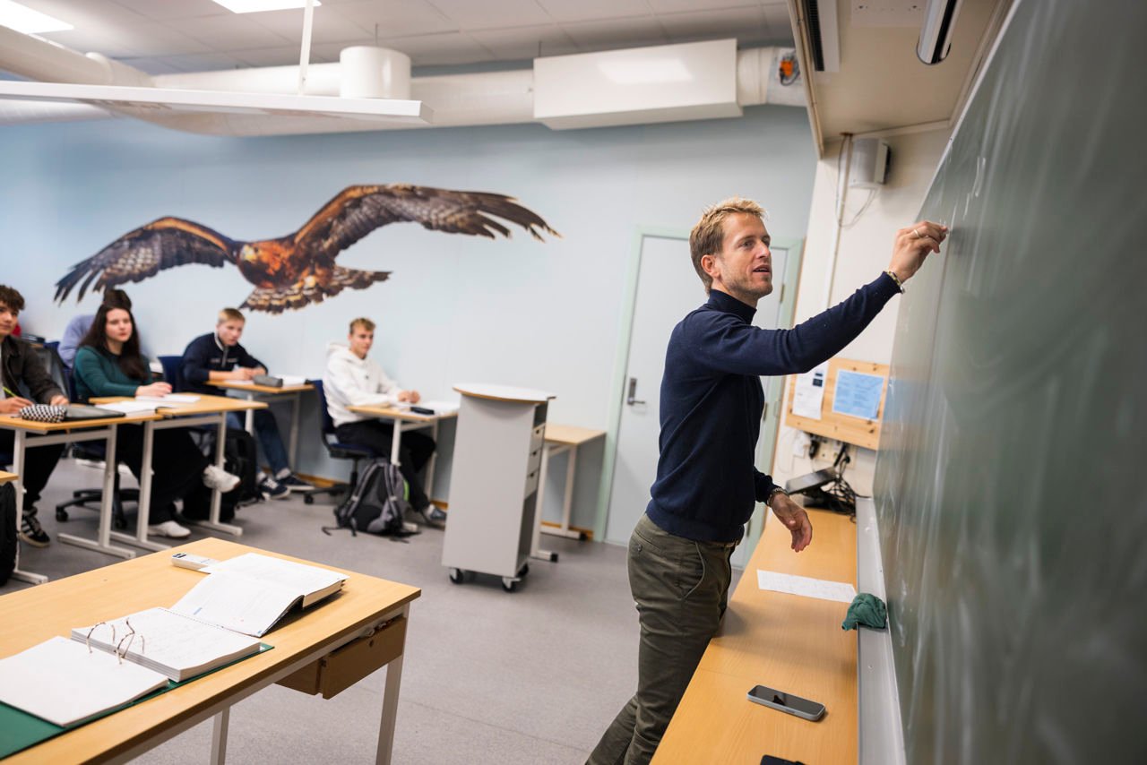 Lærar skriv på tavla. Foto: Reed foto